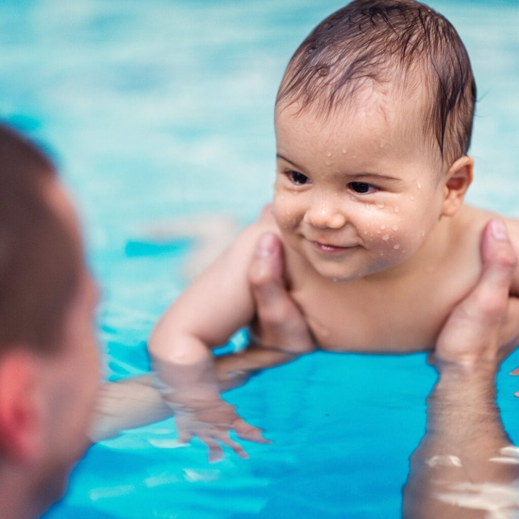 Smiling baby boy in swimming pool