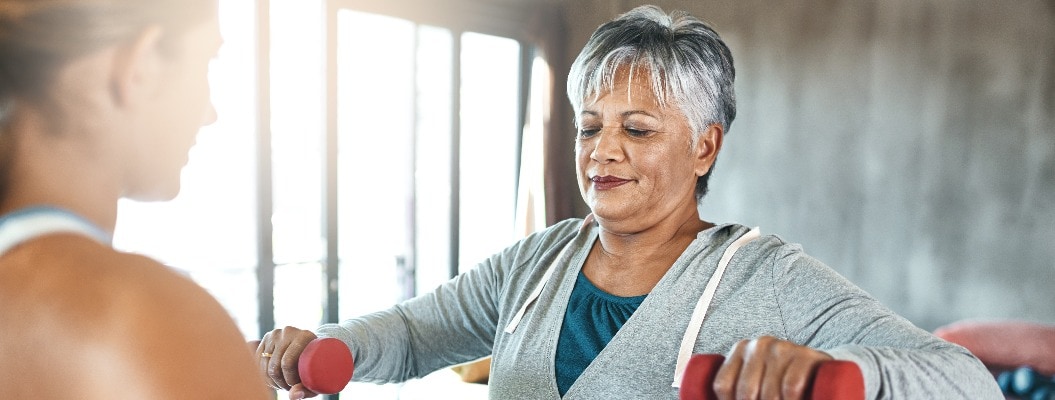 Training, Hantel und Fitness mit älterer Frau und Personal Trainer für Unterstützung, Gesundheit oder Physiotherapie. Training, Gewichtheben und Workout mit älterer Kundin und Trainerin für Seniorentraining